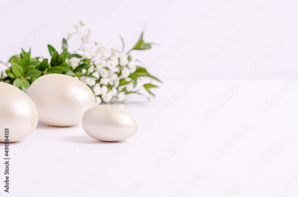 Mother-of-pearl Easter eggs with hepsophila flowers and pistachio branches on a white background. Mother-of-pearl Easter eggs with hepsophila flowers and pistachio branches on a white background.