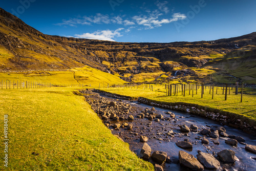 A waterfall flowing down a steep mountain slope on Streymoy Island, Tjornuvik, Faroe Islands. photo