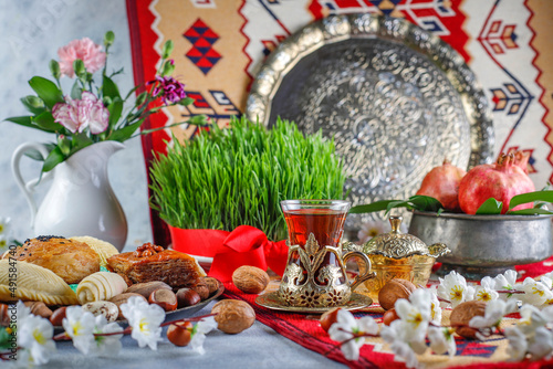 Traditional Azerbaijan spring holiday Novruz tray with semeni - wheat grass, pakhlava, shekerbura,badambura,mutaki,gogal,flowers,dry fruits,spring flowers.