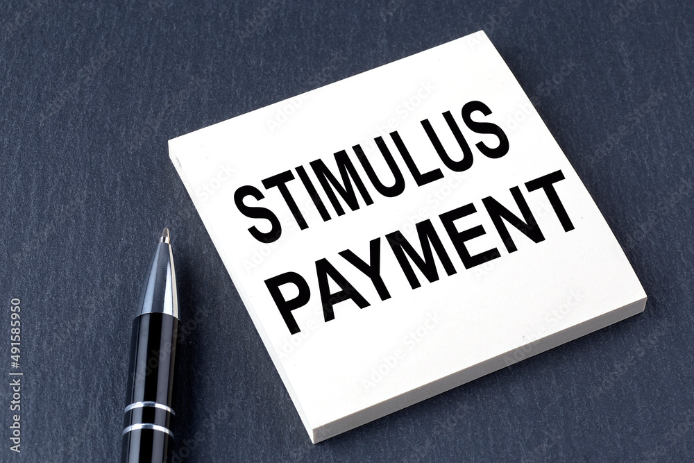 STIMULUS PAYMENT text on the sticker with pen on the black background