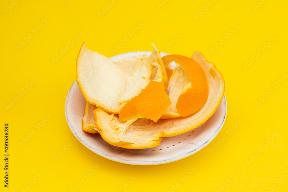 fresh orange mandarin peel on white dish on yellow fresh orange mandarin peel on white dish on yellow