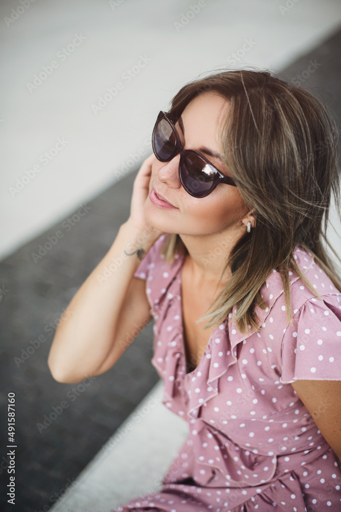 young beautiful brunette posing on the street in a soft pink sundress young beautiful brunette posing on the street in a soft pink sundress