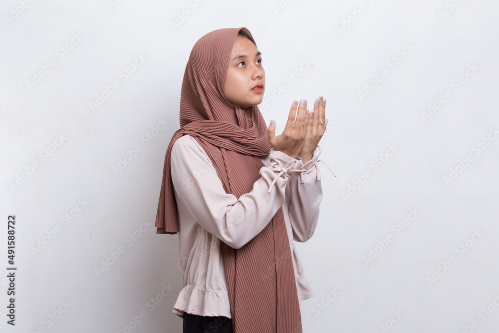Young asian muslim woman praying isolated on white background
Young asian muslim woman praying isolated on white background
