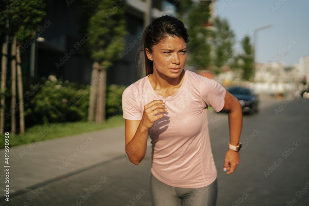 Fit athlete woman in sportswear outdoors. Young woman jogging outside. Fit athlete woman in sportswear outdoors. Young woman jogging outside.