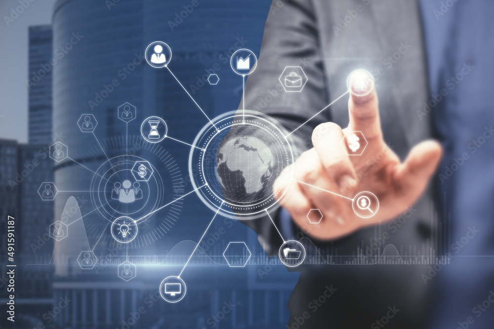Close up of businessman hand pointing at abstract glowing business data and earth hologram on blurry blue city background. Communication and media concept. Double exposure. Close up of businessman hand pointing at abstract glowing business data and earth hologram on blurry blue city background. Communication and media concept. Double exposure.
