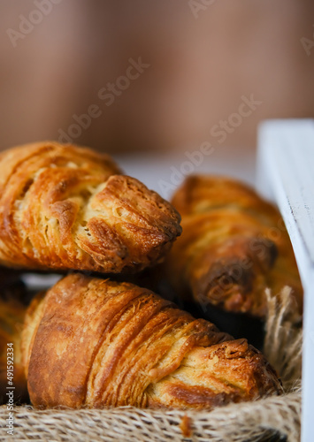 Croissants in a white wooden box. Croissant in a cut. Sliced ​​croissant. Vertical photo of croissants. puff pastries