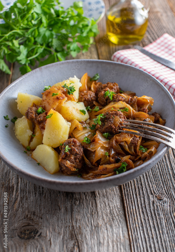 Rustic dish with meatballs, cabbage, sauce and potatoes Rustic dish with meatballs, cabbage, sauce and potatoes