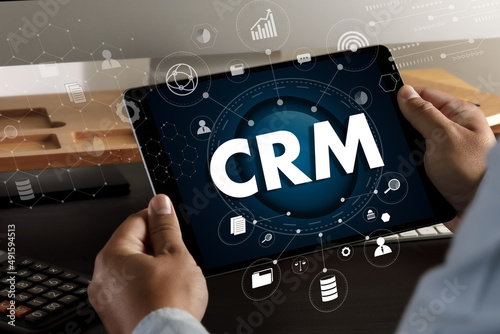 CRM Business Customer CRM Management Analysis Service Concept Business team hands at work with financial reports and a laptop.