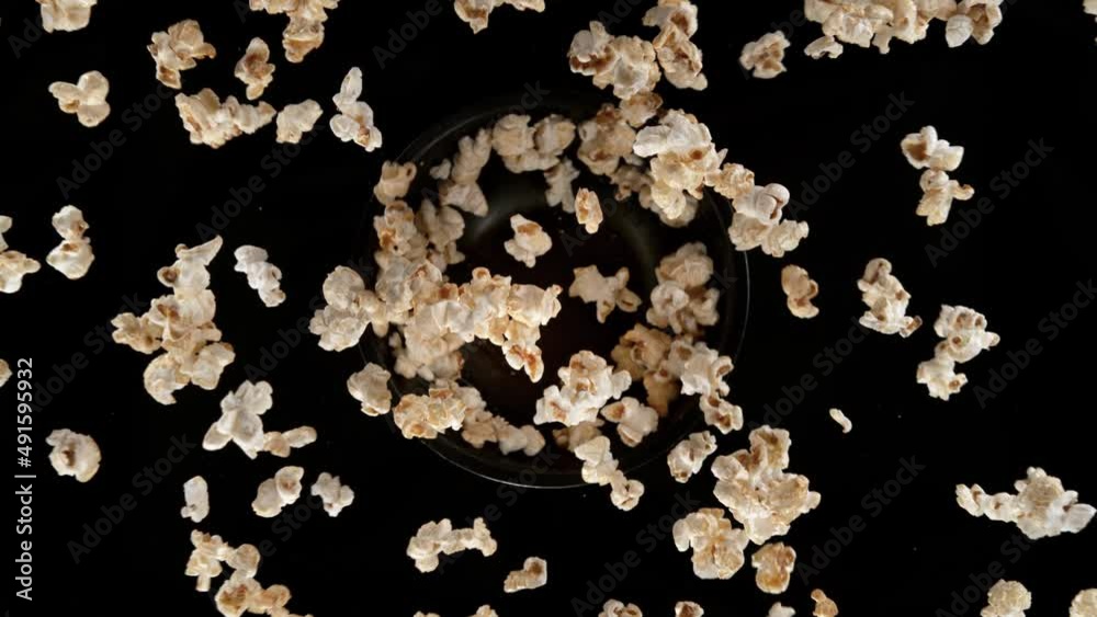 Super slow motion shot of rotating exploded fresh popcorn on black at 1000fps.