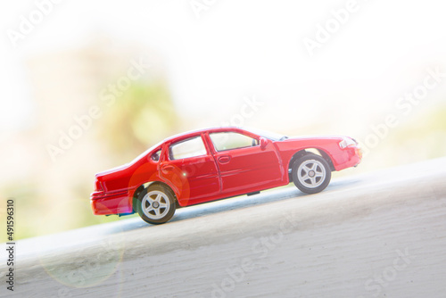 Red toy car moving up, sunshine  © ivanchik29
