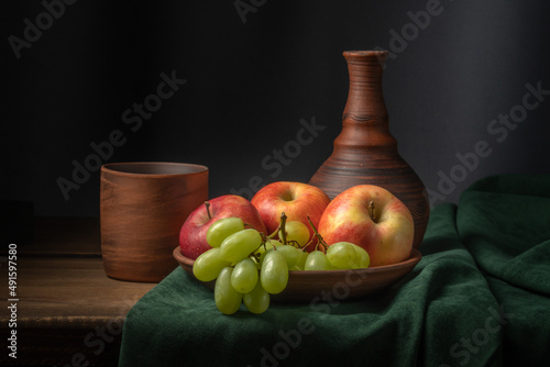 Still life with a jug of wine and fruit on a blue cloth