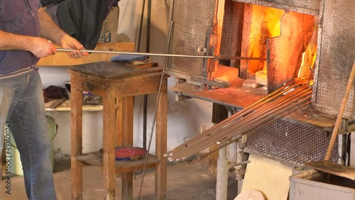  Making famous Venetian glass in Murano, glass making - actual process inside the factory in Venice - high temperature furnace oven with fire for melting