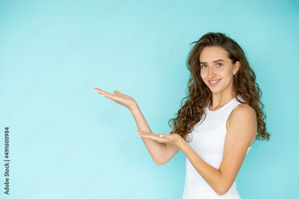 Product presentation. Happy woman. Sale discount. Pretty elegant smiling lady holding hands up isolated blue copy space. Product presentation. Happy woman. Sale discount. Pretty elegant smiling lady holding hands up isolated blue copy space.
