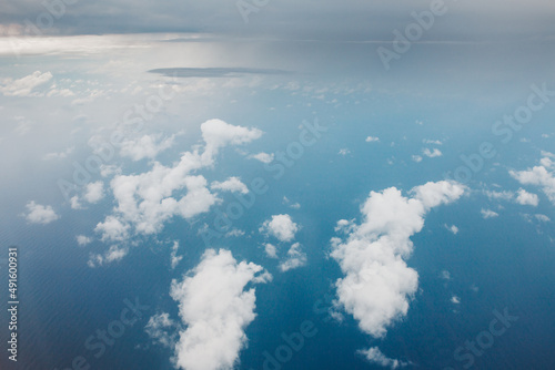 View of the earth from above through the clouds against the blue sky - the window of a flying plane