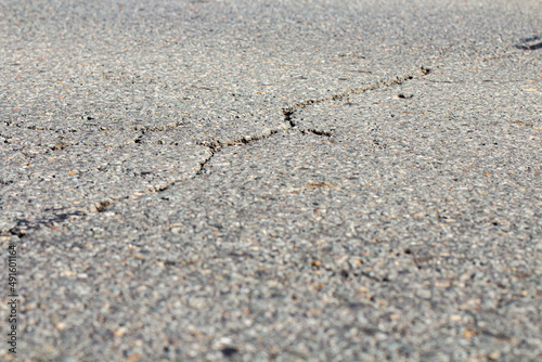 Asphalt road with cracks, close-up, backdrop or advertising background
