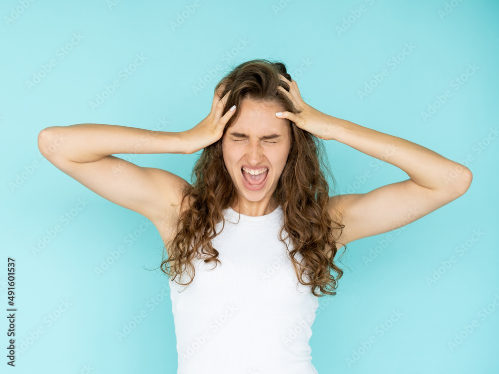 Rage power. Screaming woman. Desperate madness. aggressive shouting lady holding head with hands expressing psychology disorder isolated blue. Rage power. Screaming woman. Desperate madness. aggressive shouting lady holding head with hands expressing psychology disorder isolated blue.