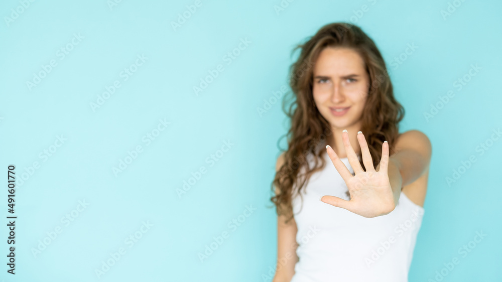 Stop gesture. Protesting woman. No way. Gloomy defocused lady in white dress holding forbidden hand up isolated blue copy space. Stop gesture. Protesting woman. No way. Gloomy defocused lady in white dress holding forbidden hand up isolated blue copy space.