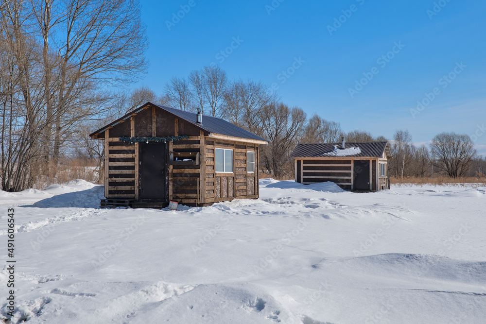 Russian wooden bath in winter. The fallen white snow lies on the ground.