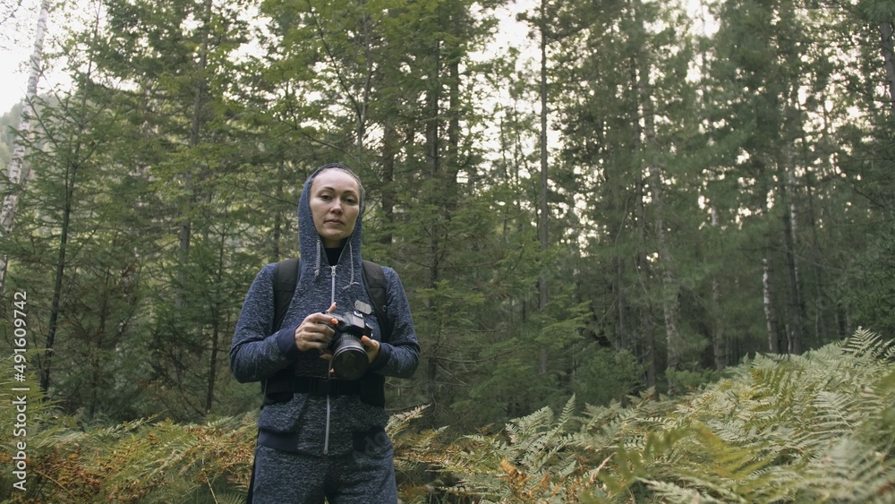 Traveler photographing scenic view in forest. One caucasian woman shooting nice magic look. Girl take photo video on dslr mirrorless camera. Professional photographer travel with backpack. Outdoor. Traveler photographing scenic view in forest. One caucasian woman shooting nice magic look. Girl take photo video on dslr mirrorless camera. Professional photographer travel with backpack. Outdoor.