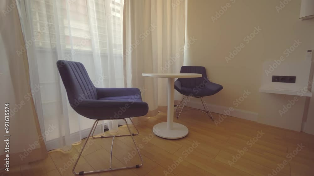 Dining table and chairs in the hotel. A decorative new modern table with chairs stands in a hotel room in an apartment by the window. Realty. Modern furniture. Dining table and chairs in the hotel. A decorative new modern table with chairs stands in a hotel room in an apartment by the window. Realty. Modern furniture.