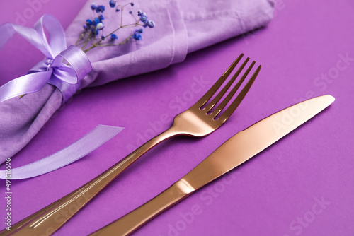 Simple table setting with flowers on purple background, closeup © Pixel-Shot