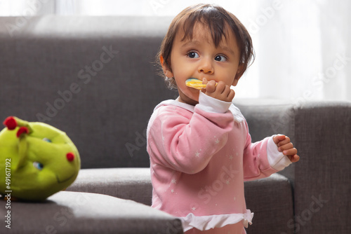 Cute baby chewing toy and looking away photo