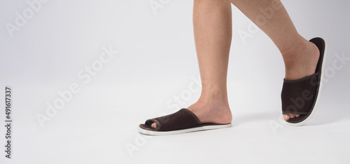Asian female foot and wear slipper isolated on white background. photo