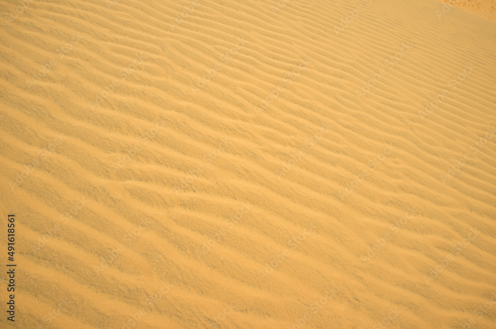 Wavy surface of sand dunes. Decoration concept. Summer background. Desert theme. Wind traces. Nature design. Picture for creative wallpaper or home art. Sand pattern. Wavy surface of sand dunes. Decoration concept. Summer background. Desert theme. Wind traces. Nature design. Picture for creative wallpaper or home art. Sand pattern.