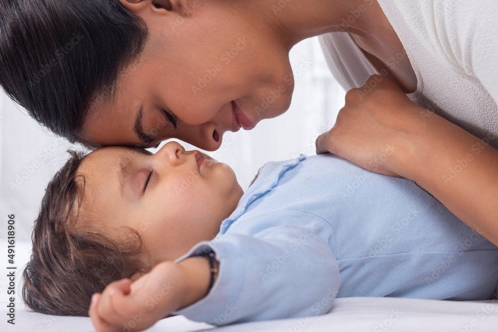 Portrait of mother caressing sleeping baby with affection Portrait of mother caressing sleeping baby with affection