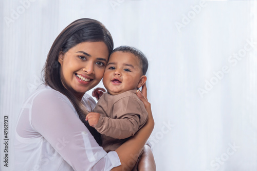 Portrait of happy mother with little baby at home photo