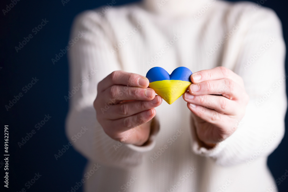 Heart flag of Ukraine in human hands. No war, peace for Ukraine concept. Heart flag of Ukraine in human hands. No war, peace for Ukraine concept.