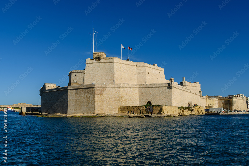 Poking into the Grand Harbour in Malta is the fortress Fort Saint Angelo, located at the end of the fortified city of Birgu (Vittoriosa). At its base on the shore is the small De Guiral Battery.