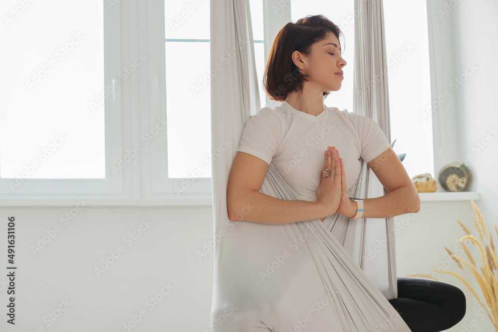 A young brunette girl does yoga, meditates on the floor in the studio, hall. A young brunette girl does yoga, meditates on the floor in the studio, hall.