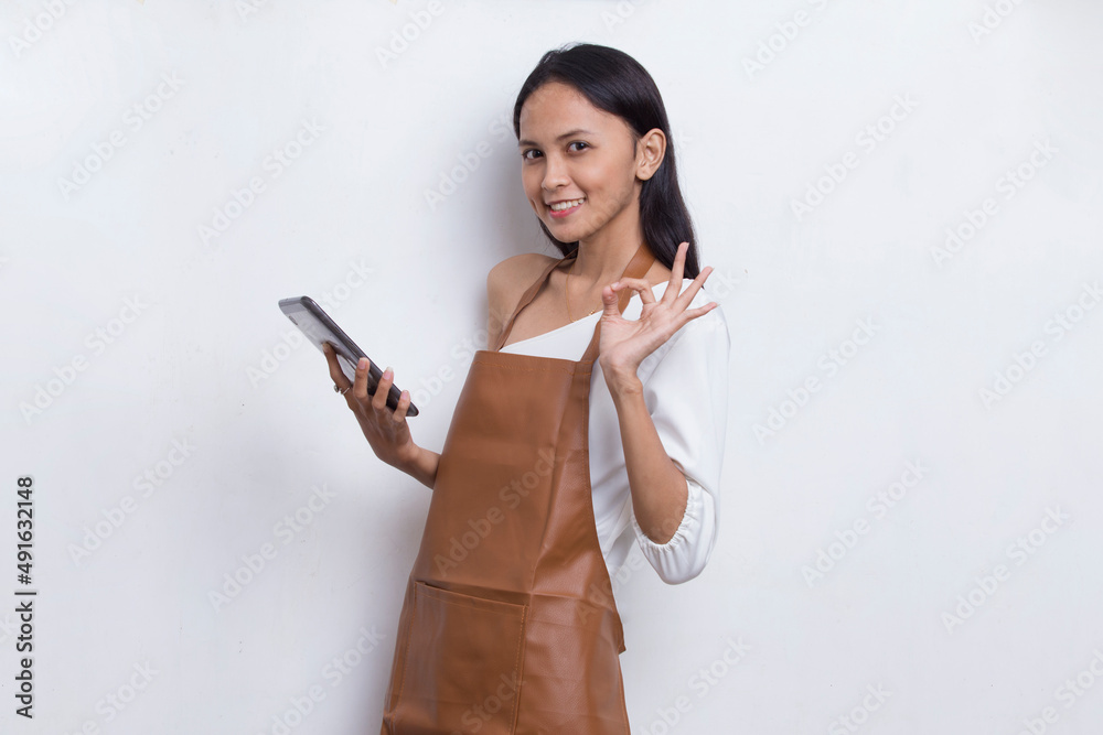 Young asian woman bartender or waitress using mobile smartphone isolated on white background
Young asian woman bartender or waitress using mobile smartphone isolated on white background