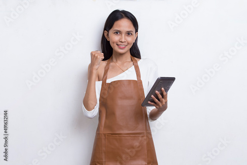Young asian woman bartender or waitress using mobile smartphone isolated on white background
