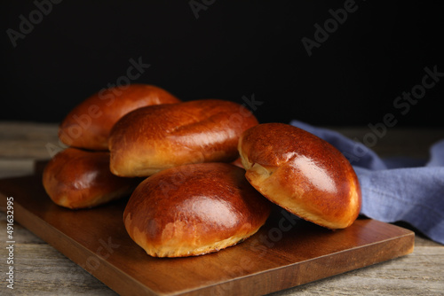 Baked pirozhki on wooden table. Delicious pastry
