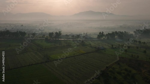 Zoom in shot of farm field at Abbottabad Pakistan. Foggy weather with mountain in the background.  photo