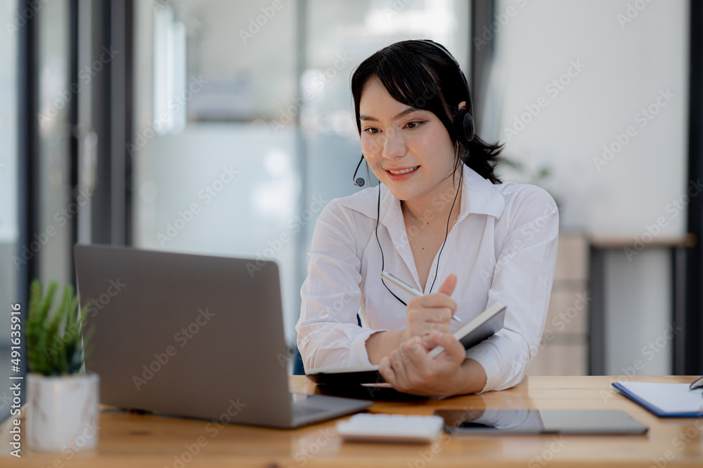 Beautiful Asian woman, she is a call center employee of an Internet and telephone company, she is responsible for providing service and assistance to customers through the phone. Call center concept. Beautiful Asian woman, she is a call center employee of an Internet and telephone company, she is responsible for providing service and assistance to customers through the phone. Call center concept.