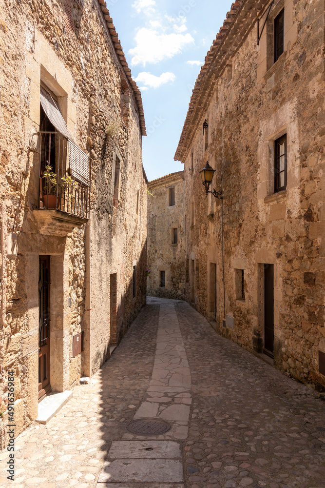 narrow stone street in the medieval town of pals on the costa brava on a sunny summer day