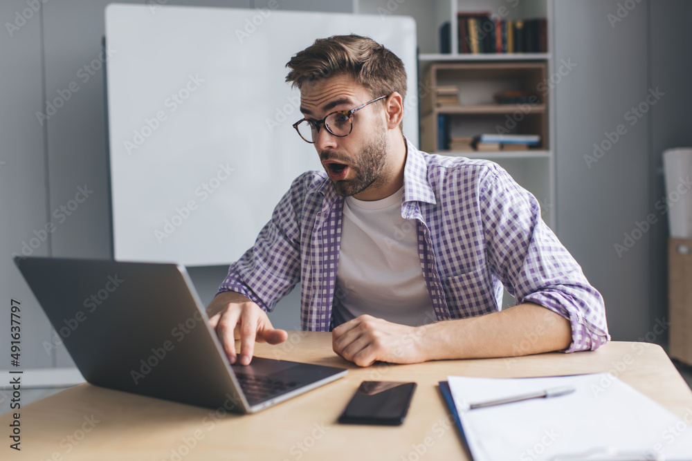 Millennial businessman working at desk in office Millennial businessman working at desk in office