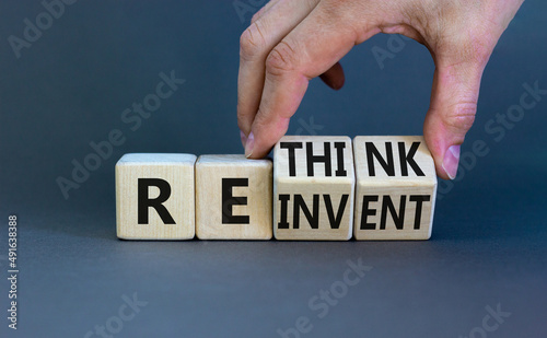 Reinvent and rethink symbol. Businessman turns cubes and changes the concept word Reinvent to Rethink . Beautiful grey table grey background. Business reinvent and rethink concept. Copy space. photo