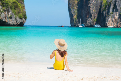Woman tourist in yellow swimsuit and hat  happy traveller sunbathing at Maya Bay beach on Phi Phi island  Krabi  Thailand. landmark  destination Southeast Asia Travel  vacation and holiday concept