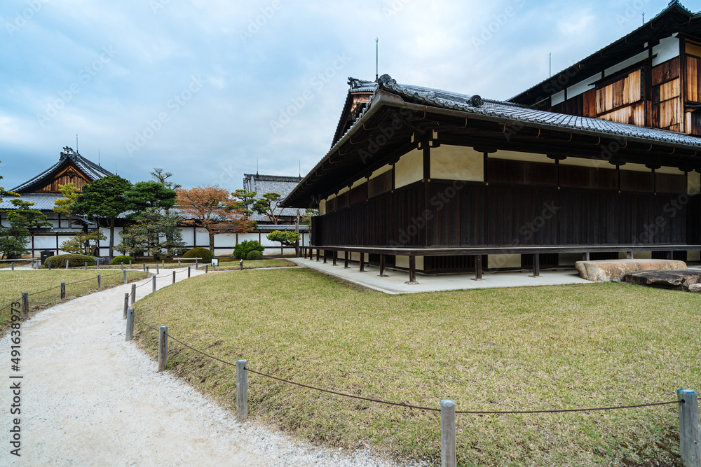 view of curved path outside an ancient japanese religious building. picture of pathway winding along the lawn in front of a zen buddhist temple. view of curved path outside an ancient japanese religious building. picture of pathway winding along the lawn in front of a zen buddhist temple.