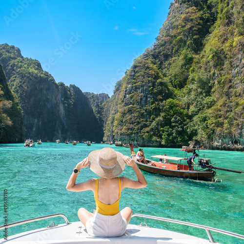 Woman tourist on boat trip, happy traveller relaxing at Pileh lagoon on Phi Phi island, Krabi, Thailand. Exotic landmark, destination Southeast Asia Travel, vacation and holiday concept