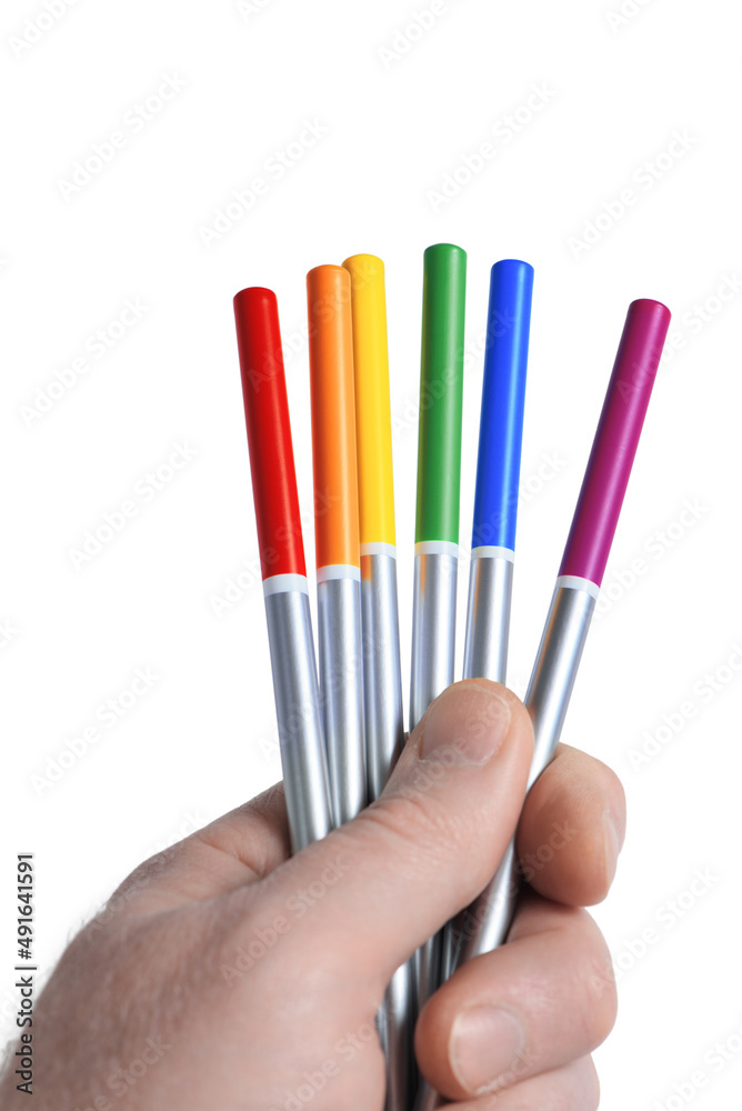 Male hand holding six bright colored pencils in LGBT rainbow colors, isolated on white background. Colorful life concept. Closeup.