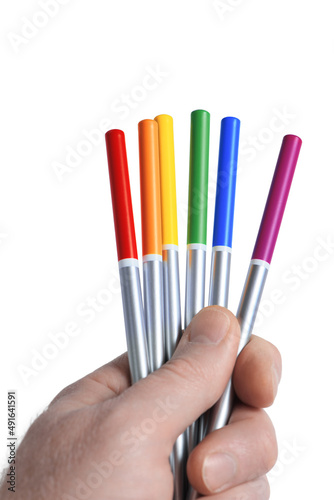 Obraz na płótnie Male hand holding six bright colored pencils in LGBT rainbow colors, isolated on white background. Colorful life concept. Closeup. w salonie