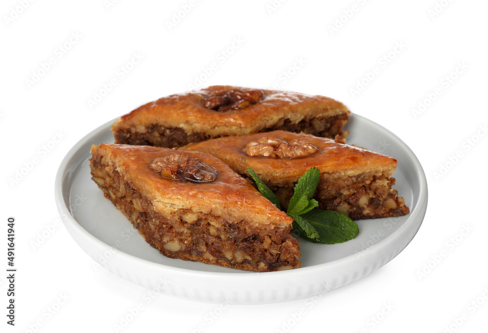 Plate of delicious honey baklava with walnuts on white background