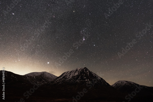 Glen Etive astrophotography with the Milky Way and Orion rising above a snowy mountain peak