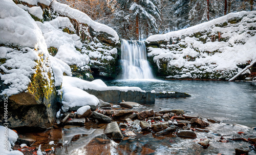 Fototapeta Naklejka Na Ścianę i Meble -  Scenic waterfall covered by snow during winter