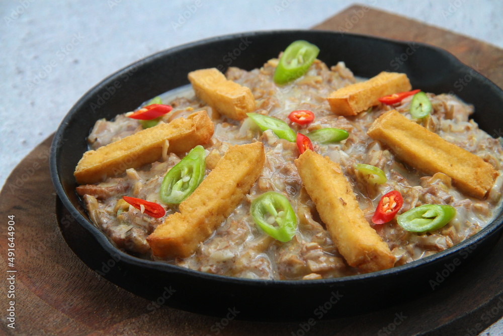 Freshly made Filipino food called Pork Sisig or chopped pork served in a hot plate Freshly made Filipino food called Pork Sisig or chopped pork served in a hot plate